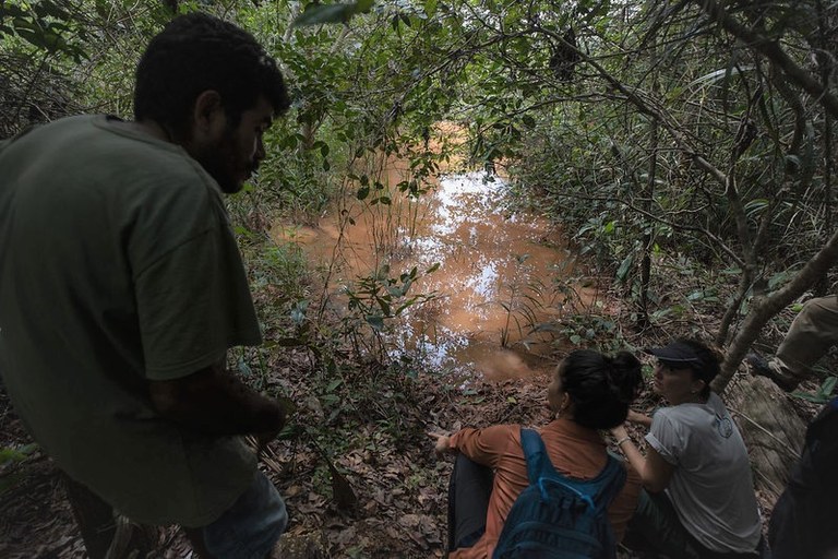 Indigenous man talks with researchers on the banks of the Pindaré river